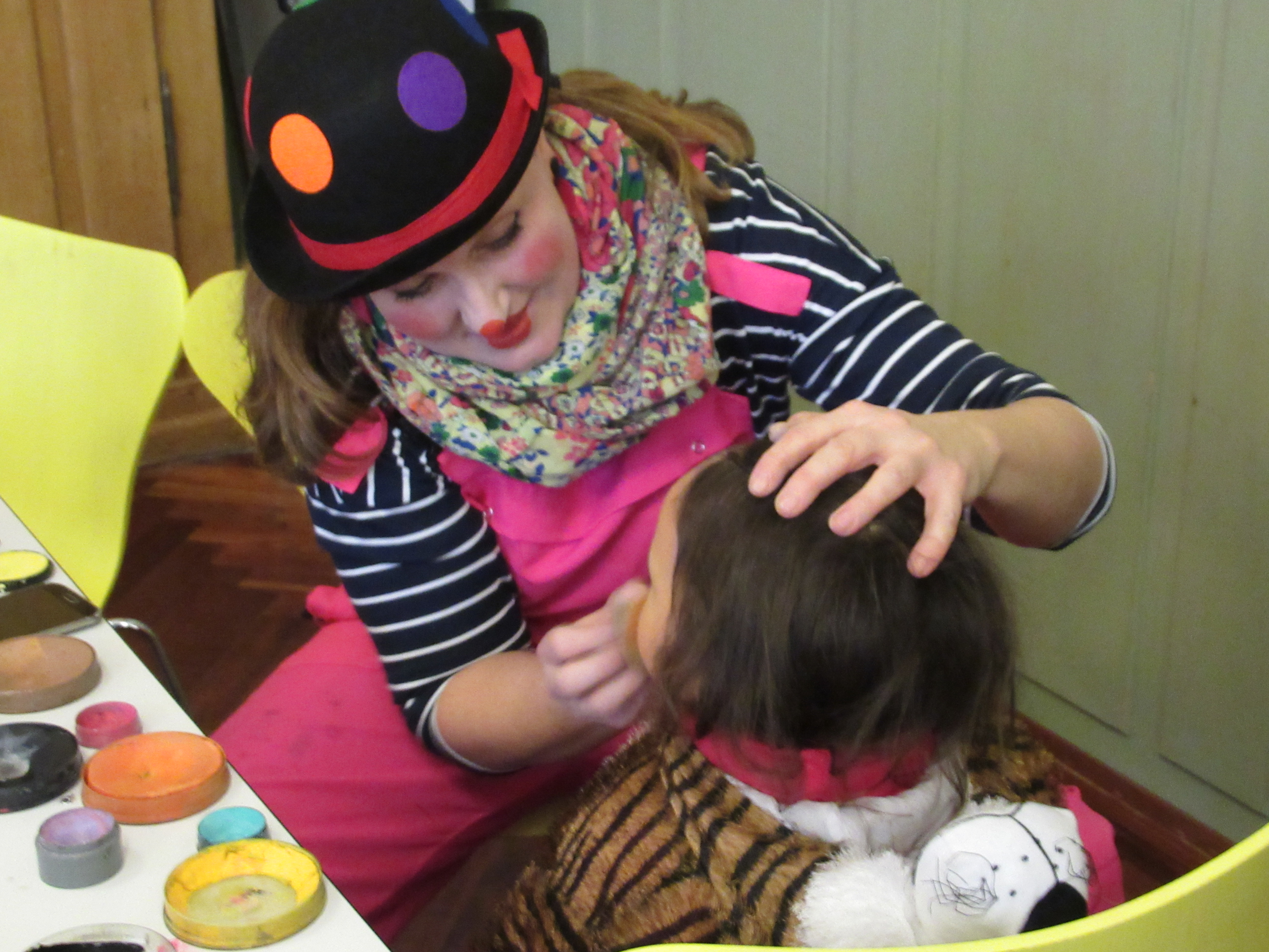 Clownin schminkt ein Kind